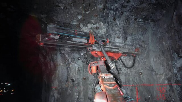 This view from the operator's cabin shows an industrial drilling machine in an underground gold mine.
