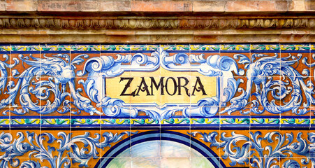 Tile with the name of the spanish city of Zamora on ceramic  with a colorful decoration located in Spain Square in Seville