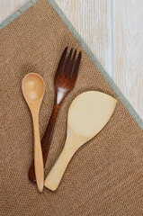 Wooden kitchen appliances spoon fork on a wooden kitchen table with space for text, eco tableware concept