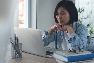 Young asian business woman serious working on laptop computer from home office