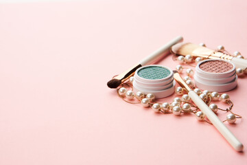 makeup brushes and eyeshadow professional cosmetics on pink background