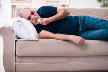 Old man with injured eyes resting at home