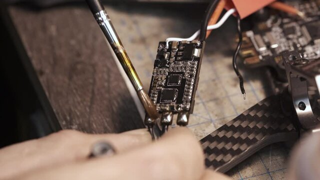 The guy paints the FPV chip of the drone with a brush