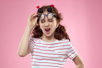 Cheerful girl with pigtails sunglasses striped t-shirt lifestyle pink background