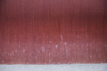 Red rusty metal wall background with gravel and scratches
