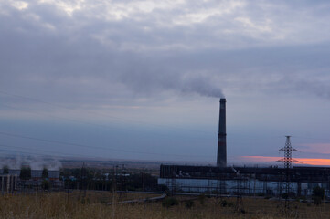 Industrial landscape at sunset, pipes and smoke. Smog and environmental problems.