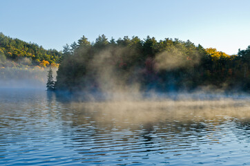 Sunrise above forest lake