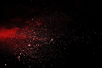 Red powder explosion on black background. Paint Holi.