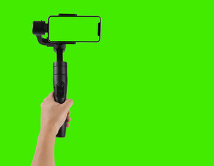 Man filming with a blank screen smartphone using a gimbal stabilizer, isolated on green background chroma key