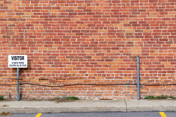 Antique grungy reddish brown brick wall texture background in a common bond brickwork pattern, with copy space