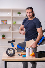 Obraz na płótnie Canvas Young male repairman repairing skateboard