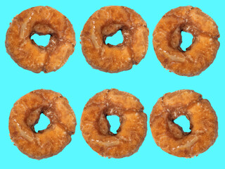 Old fashioned cake donuts on a teal colored background.
