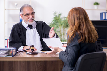 Old male judge and female client in the office