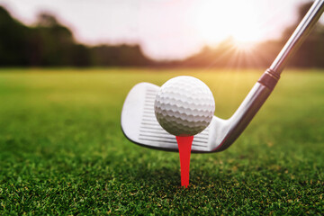 close up golf club and golf ball on green grass with sunrise background - Powered by Adobe