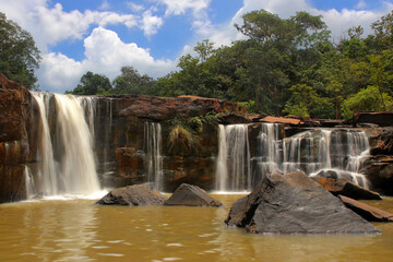 Obraz premium waterfall in forest with beautiful sky background