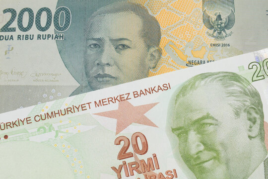 A macro image of a grey two thousand Indonesian rupiah bank note paired up with a green, twenty Turkish lira bank note.  Shot close up in macro.