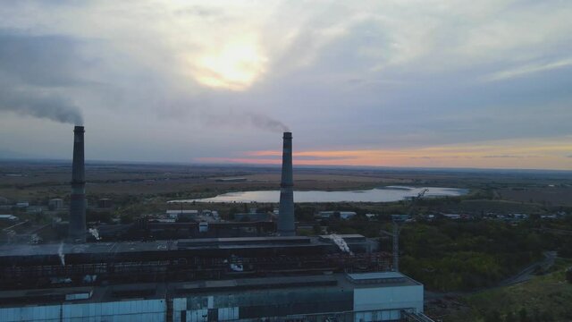 Large chimneys of an industrial plant emit smoke into the atmosphere. Ecology problem, environmental pollution. Heat station.
