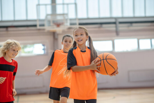 Kids in bright sportswear having basketball game