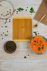 Autumn delicious healthy food, hearty pumpkin soup top view, healthy nutrition on autumn dinner, the concept of thanksgiving day, empty wooden cutting board copy space or design