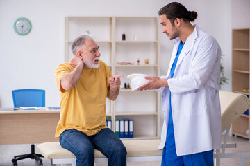 Fototapeta premium Old neck injured man visiting young male doctor