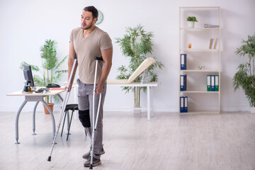 Young leg injured man with crutches