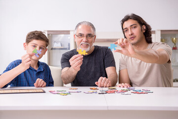 Three generations of family playing jigsaw puzzle game