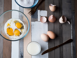 process of making omelet from natural eggs and products. Milk, salt, eggs. Cup for whipping omelet. Fork and knife. Frying pan and oil