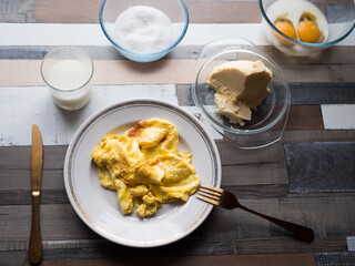 process of making omelet from natural eggs and products. Milk, salt, eggs. Cup for whipping omelet. Fork and knife. Frying pan and oil
