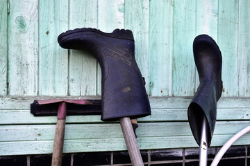 rubber boots hang on the shovel handles