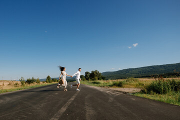 A couple running across the country road at the fields