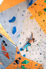 A man is climbing a climbing wall