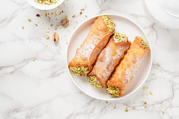 Sweet homemade cannoli stuffed with ricotta cheese and pistachio. Sicilian dessert. Italian pastry.	