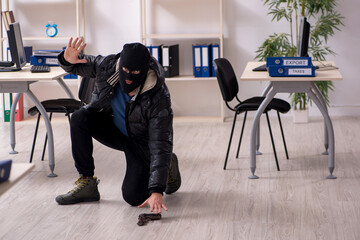 Young male burglar in the office
