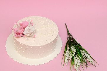 Hermoso pastel decorado con peonías cobre fondo rosa. Aislado, con espacio.