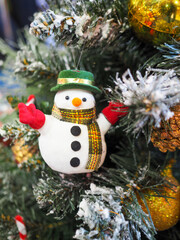 A snowman hanging on a christmas tree