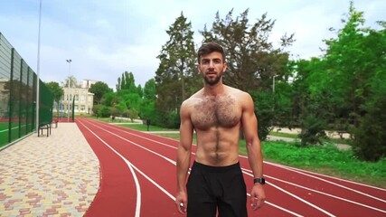 Portrait of a tired, shirtless man going on stadium race after hard training