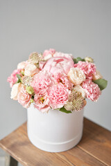 Beautiful spring bouquet in round box. Arrangement with various flowers. The concept of a flower shop. A set of photos for a site or catalogue. Work florist.