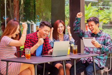 Happy young people celebrating success in the cafe