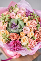 Beautiful spring bouquet on wooden table.. Arrangement with various flowers. The concept of a flower shop. A set of photos for a site or catalogue. Work florist.