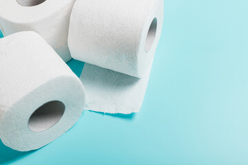 Three roll of white toilet paper on a blue background.