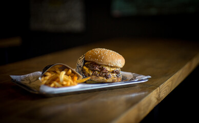 Double Patty Juicy Burger on a wooden Cafe table