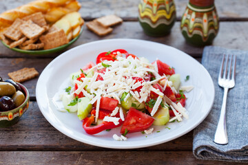 Vegetable Bulgarian Shopska salad. Wooden background. Close up.