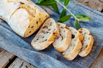 Ciabatta bread with olive branch. Wooden background. Close up.