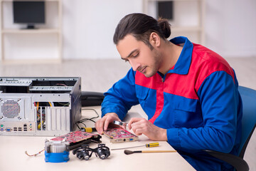 Young male repairman repairing computer