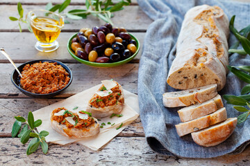 Ciabatta bread bruschetta with olive tapenade. Wooden background. Top view.