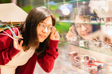 Beautiful businesswoman buying new glasses in optician shop.