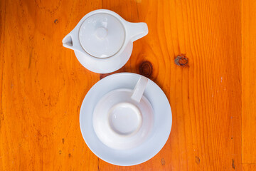 White Coffee pot and White cup of coffee on wooden table and leave space for adding your content.