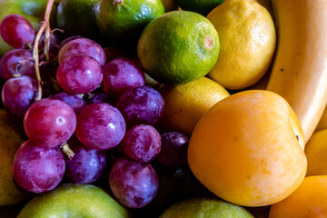 Obstschale mit frischem Obst Zitronen Orangen Limetten, Trauben Bananen
