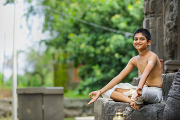 the indian priest child doing meditation