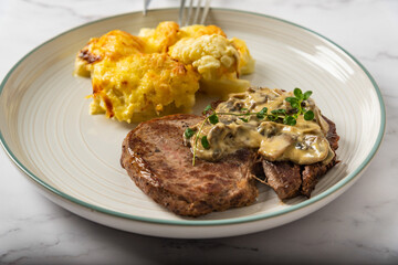 Eye fillet served with cauliflower gratin and mushroom sauce 